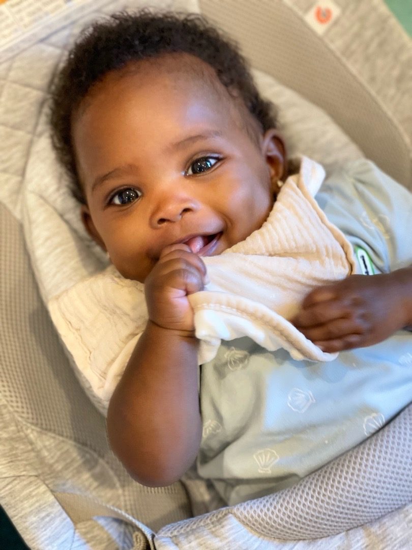 A smiling infant resting comfortably