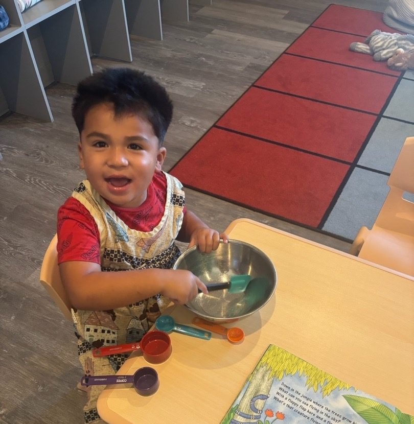 A toddler stirring a mixing bowl during a hands-on measuring activity